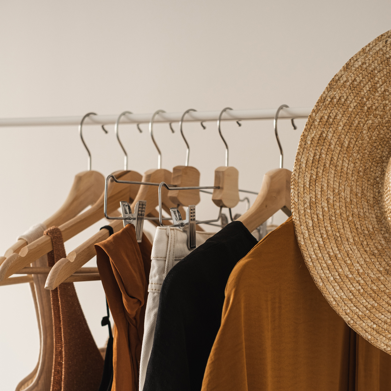 Neutral Clothes on Clothing Rack with a Hat